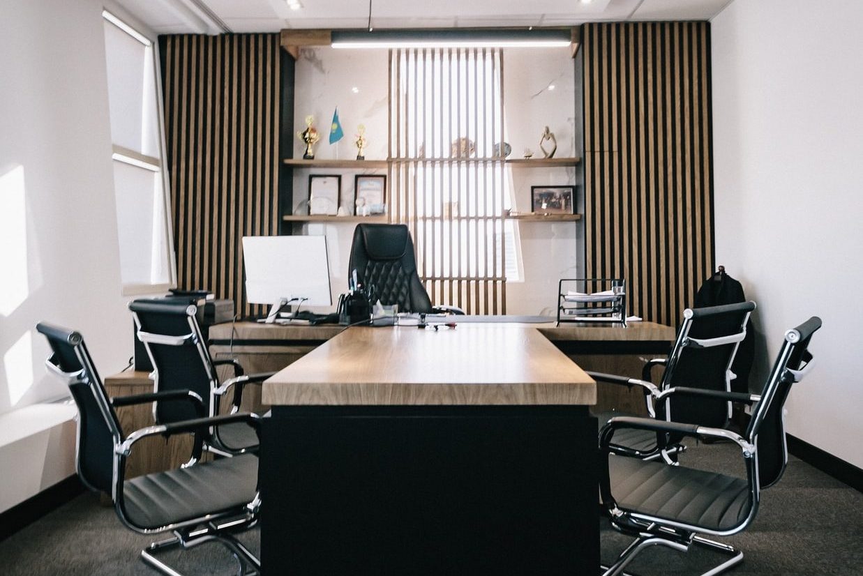 brown and black office table and four black cantilever chairs